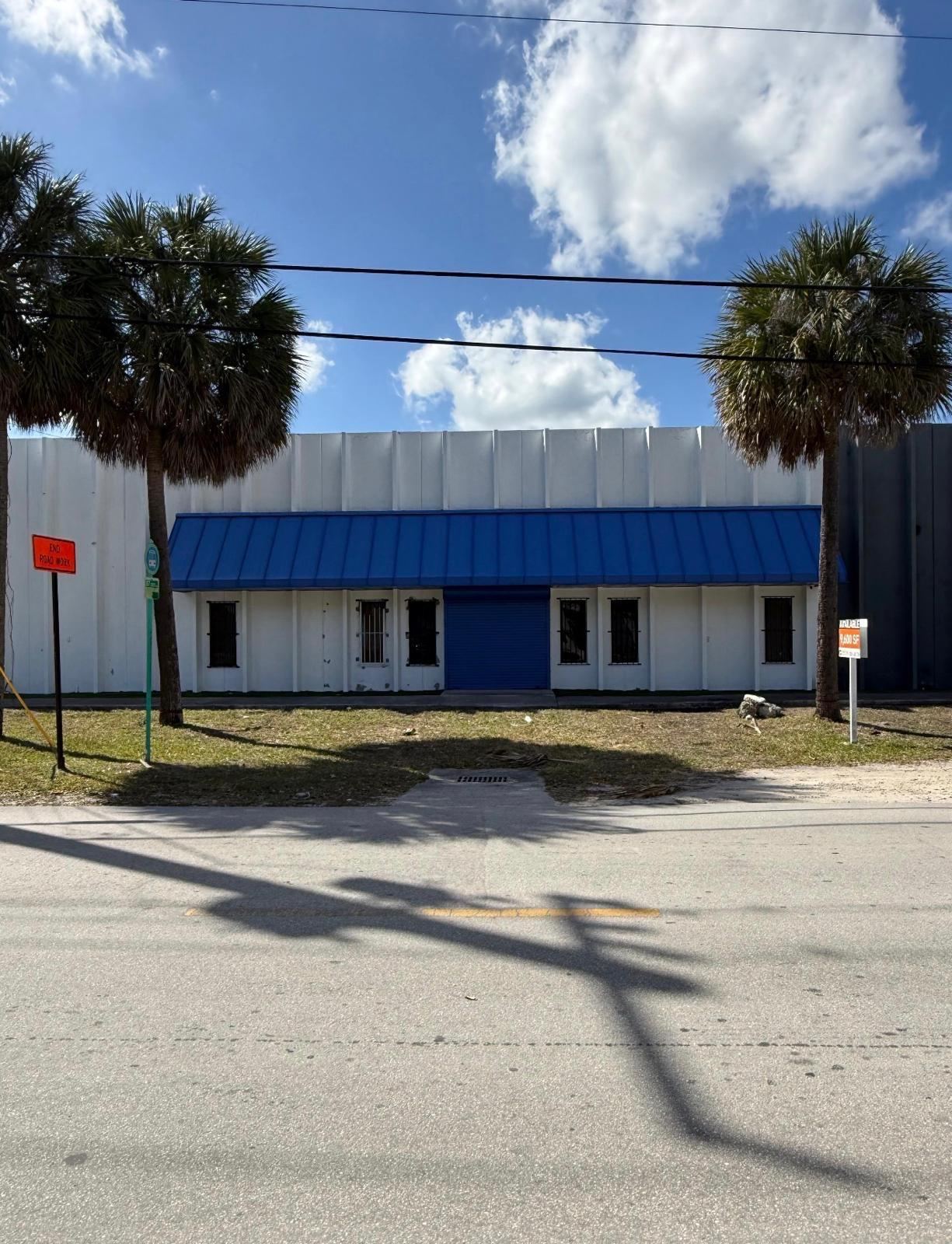 The same storefront before painting, with a faded blue awning