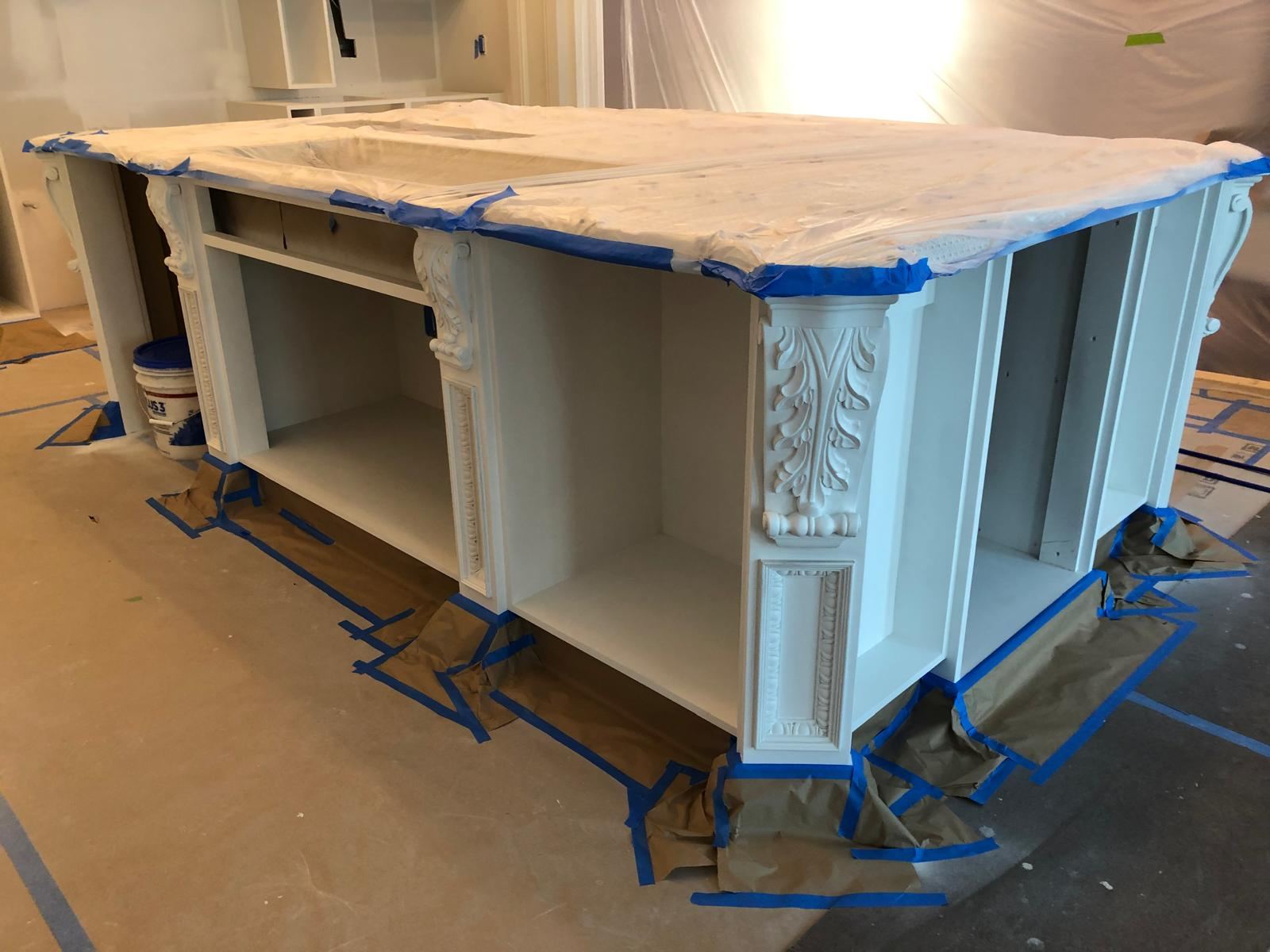 Kitchen island with countertop and floor protected during painting
